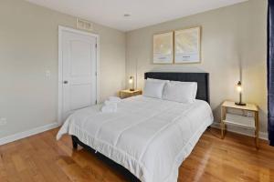 a bedroom with a large white bed with two lamps at Stylish and Comfortable 1-BR in the Heart of Detroit in Detroit