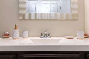 a white bathroom sink with a mirror above it at Stylish and Comfortable 1-BR in the Heart of Detroit in Detroit