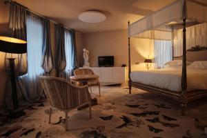 基輔的住宿－瓦斯里湛斯基精品酒店，卧室配有1张床、1张桌子和1把椅子