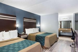 Tempat tidur dalam kamar di Red Carpet Inn & Suites NJ-73