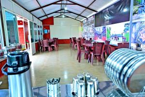 a dining room with tables and chairs in a restaurant at Coffee Crown Homestay - Water Falls, Trek, Home Food, Estate in Sakleshpur