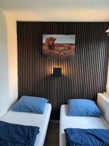 een kamer met twee bedden en een foto aan de muur bij Gehele Bungalow Simpelveld op een park in Simpelveld