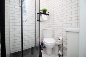 a white bathroom with a toilet and a sink at Modern 2 Bedroom Flat in Robert st, Swansea in Swansea