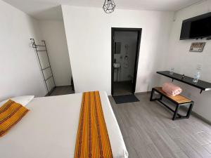 a bedroom with a bed and a table and a chair at Casa Malva Sweet Stay in Guanajuato