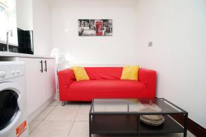 a red couch with yellow pillows in a living room at Modern 2 Bedroom Flat in Robert st, Swansea in Swansea