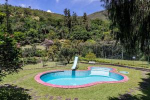 uma piscina no meio de um quintal em Aconchegante Sítio na Serra com piscina em Itaipava 26 hóspedes em Itaipava