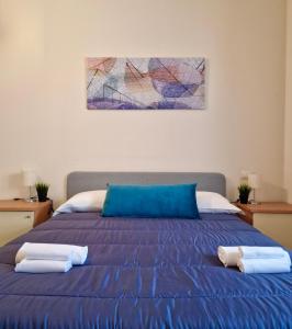 una camera da letto con un letto blu con due asciugamani di Casa Adelina by TraMonti Apartments a Poggio Picenze