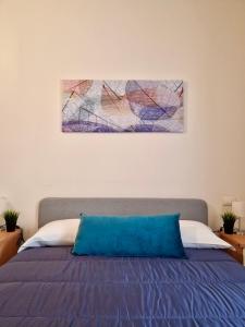 un letto con un cuscino blu sopra di Casa Adelina by TraMonti Apartments a Poggio Picenze