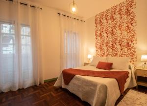 um quarto com uma cama e uma grande janela em O sete dos Soportais em Pontevedra