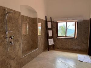W łazience znajduje się prysznic ze szklanymi drzwiami. w obiekcie David Livingstone's Home w mieście Zanzibar
