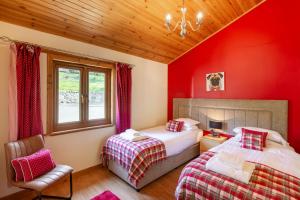 a red bedroom with two beds and a chair at Mountain Ash Lodge with Hot Tub in Cupar
