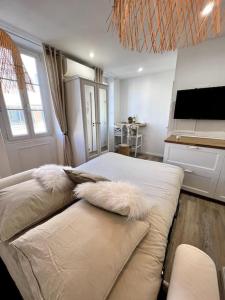 a living room with a couch with pillows on it at Studio 2 neuf à 100m des plages et de la gare in Saint-Raphaël