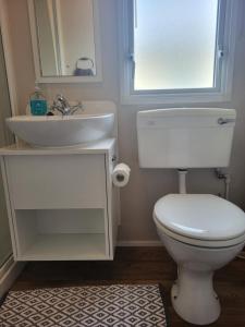 uma casa de banho com um WC branco e um lavatório. em Beach View em Whitstable