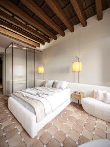 a bedroom with a large white bed and a couch at YourSuiteRome in Rome