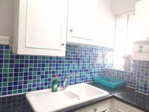 a kitchen with a sink and a blue tiled wall at Beautiful 2 Bedroom Flat in Frampton Street in London