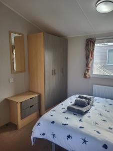 a bedroom with a bed and a cabinet and a window at Beach View in Whitstable