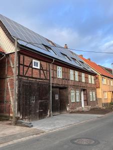 un antiguo edificio de ladrillo con paneles solares. en Allenberghütte Schoningen en Uslar