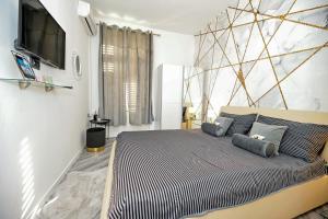 1 dormitorio con 1 cama y TV en la pared en Luxury Apartment Laura, en Zadar