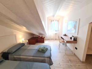 een slaapkamer op zolder met 2 bedden en een bureau bij Ca' Nova - Burano in Burano