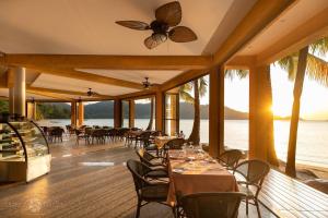 een restaurant op het strand met tafels en stoelen bij Dragon Sea View Villa in Ko Chang