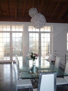 una sala da pranzo con tavolo in vetro e sedie bianche di Casa do Ananas, cliff-top/ocean-front villa, Pico a Lajes do Pico