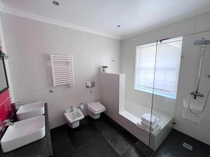 uma casa de banho com 2 WC, um chuveiro e um lavatório. em Casa do Ananas, cliff-top/ocean-front villa, Pico em Lajes do Pico