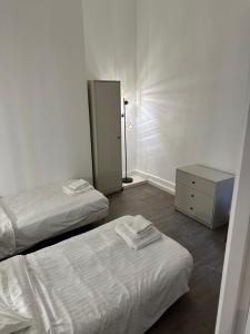 a room with two beds and a dresser and a mirror at Temple Apartments Paris in Paris