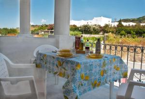 una mesa con un mantel azul y amarillo en el balcón en Casa Basilio con bellissima terrazza vista isole, en Lipari