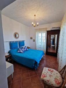 a bedroom with a blue bed and a chair at Appartement Palazzo Patrimonio in Patrimonio