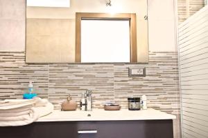 y baño con lavabo y espejo. en Casa Basilio con bellissima terrazza vista isole, en Lipari