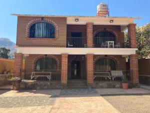 a brick building with chairs and a balcony at Hostal Casa Flor de Limón in Tepoztlán