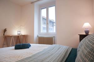 a bedroom with a bed with a blue bag on it at Appartement 3 pièces, idéal famille et travail, parking gratuit in Mulhouse