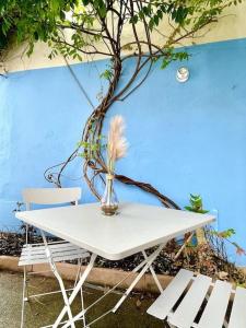 a white table with a plant in a vase next to two chairs at RDC Parfait pour halte et séjour 2 chambres, tram-train, autoroute à proximité, parking gratuit in Mulhouse