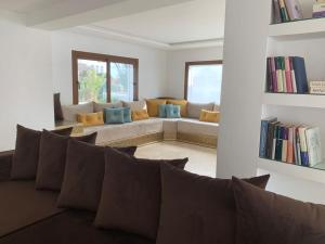 a living room with a couch with pillows at Villa Jasmin 15 in M'diq