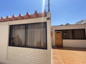 Casa blanca con ventana y puerta en Hospedaje 2174, en Iquique