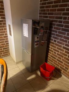 a refrigerator with a red basket next to a brick wall at Haus Erlenweg in Neuenkirchen-Vörden