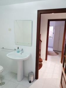 baño con lavabo y espejo en la pared en Casa pequeña y acogedora en casco histórico, en Pobra do Caramiñal