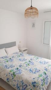 1 dormitorio con 1 cama con edredón de flores en Casa pequeña y acogedora en casco histórico, en Pobra do Caramiñal