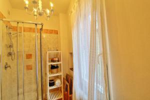 een badkamer met een douche en een kroonluchter bij Casa Peppa in Lazise