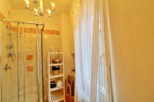a bathroom with a shower and a chandelier at Casa Peppa in Lazise