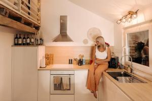 a woman sitting on a kitchen counter talking on a cell phone at La Love Story in Hastière-par-delà