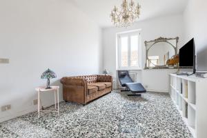 ein Wohnzimmer mit einem Sofa und einem Stuhl in der Unterkunft The Roof Apartment - CityCenter - by HOST4U in Pavia