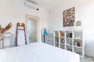 ein Schlafzimmer mit einem weißen Bett und einem Bücherregal in der Unterkunft The Roof Apartment - CityCenter - by HOST4U in Pavia