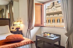 a bedroom with a bed and a window with a clock at Colonna Palace Hotel in Rome