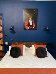 Dormitorio con cama con cabeza de ciervo en la pared en Logis Hôtel Le Cygne, en Le Bugue