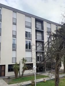 a white building with balconies and trees in front of it at Appart Hotel Corte HR in Corte