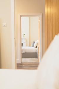 uma vista para um quarto com uma cama através de um espelho em The Milkmans Residence em Bournemouth