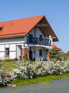 a white house with an orange roof at Storczykowe Wzgórze in Paszowice