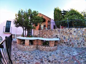 eine Steinmauer mit einer Bank vor einem Gebäude in der Unterkunft Casa Malva Sweet Stay in Guanajuato