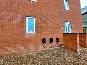 Una pared de ladrillo rojo con tres teléfonos. en Apartment Balmoral Road, en Northampton